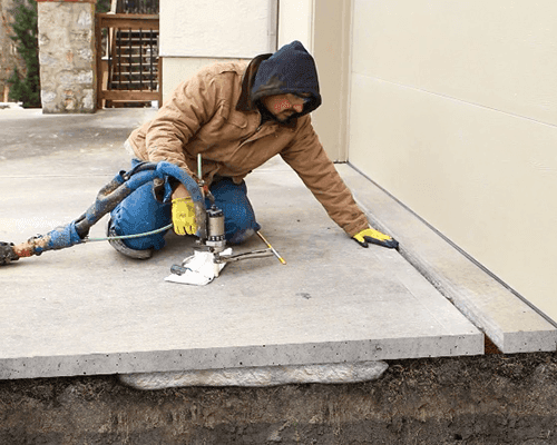 Technician completing polyurethane foam concrete lifting